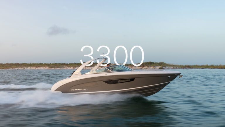 Luxury Regal 3300 bowrider cruising at high speed along a coastal shoreline during sunset